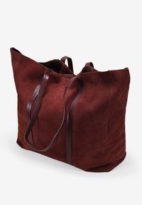 Amplia bolsa de tote de ante burdeos con dos asas de cuero marrón oscuro, que cuenta con un espacioso compartimento principal y una textura suave.