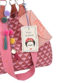 Borsa a spalla rosa con motivo geometrico, caratterizzata da dettagli in pelle, pompon colorati e un'etichetta di Frida Kahlo. Dettagli ricamati visibili.
