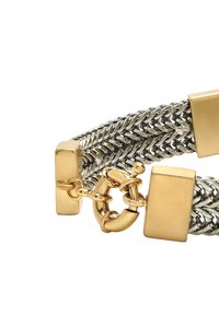 Metalowa bransoletka z przeplatanymi srebrnymi łańcuchami z złotymi akcentami. Prostokątne ogniwa i okrągłe zapięcie dodają konstrukcyjnych detali.
