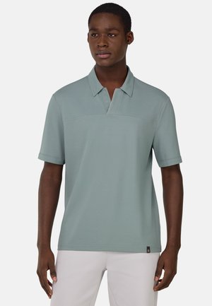 Vaaleanvihreä polo-paita, jossa lyhyet hihat, pehmeä tekstuuri, kauluksellinen muotoilu ja hienovarainen logo yksityiskohta kaula-aukon lähellä. Muotoiltu istuvuus.