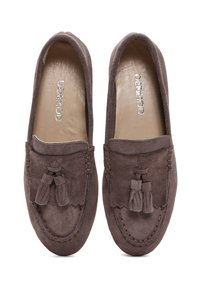 Mocassins en suede marron avec des accents à pampilles, bout arrondi et bordure cousue. Doublure intérieure douce pour un confort accru.
