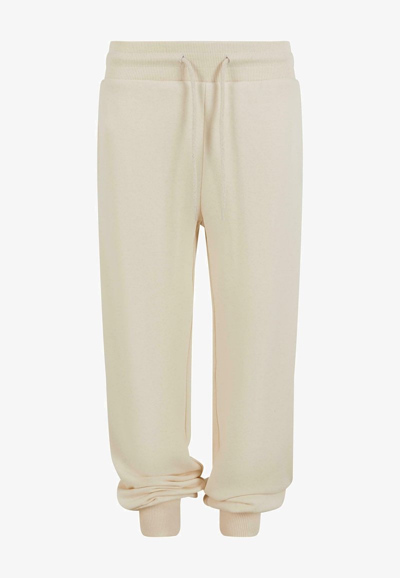 Beidzēti bēšas sporta bikses ar auklu viduklī, ribotiem garumiem un mīkstu tekstūru. Dizainam ir brīvs piegriezums komfortam.