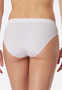 White cotton bikini briefs with a plain design, featuring a soft elastic waistband and smooth texture. Back view showing coverage line.