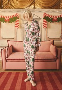 Pajama komplet s dolgimi rokavi v roza barvi z prazničnimi vzorci dreves, snežakov in božičnih motivov; vsebuje zeleni rob in rdeče obrobe. Narejen iz mehkega materiala.