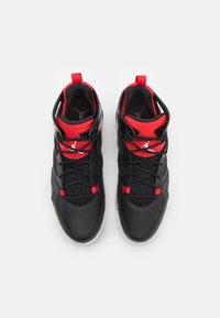 Černé a červené sportovní boty s vysokým střihem, které mají koženou a síťovanou texturu, kulaté tkaničky a logo na boku.