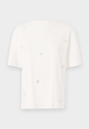 T-shirt de algodão branco com mangas curtas, apresentando pequenos enfeites em forma de coração prateado espalhados pelo tecido. Decote redondo.