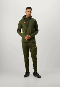 adidas Performance TIRO25 ESSENTIALS WINTERIZED TRAINING TOP MEN - Φούτερ με κουκούλα - night cargo/tent green/impact orange