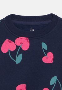 Sweatshirt para bebé azul-marinho com gola canelada e cerejas cor-de-rosa em forma de coração com folhas verdes estampadas no tecido.