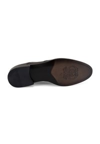 Semelle de chaussure en cuir noir avec une semelle intérieure texturée marron foncé, dotée d'une empreinte de logo circulaire et d'un talon noir surélevé.