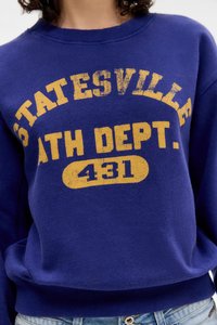 Sweatshirt roxo com texto vintage amarelo "Statesville Ath Dept. 431." Punhos e barra canelados, textura suave, corte casual.