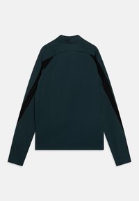 Camiseta de manga larga en azul oscuro con acentos negros; presenta un cuello alto y sin cierres visibles; textura suave y diseño atlético.