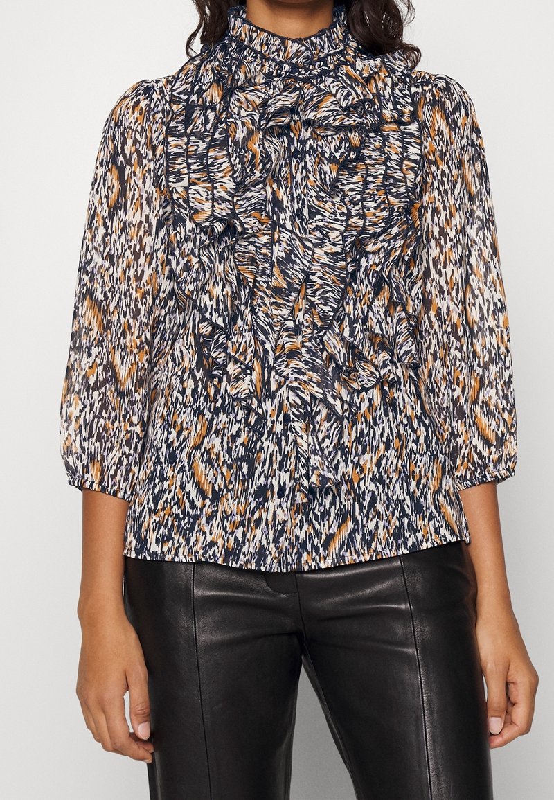 Blusa multicolore con colletto arricciato, stampata in blu navy, arancio e bianco. Presenta maniche lunghe a sbuffo e una superficie texture.