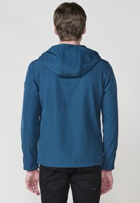 Giacca hoodie blu con una superficie texture, cappuccio e design aderente. Presenta un aspetto snello e dettagli di cuciture a contrasto.