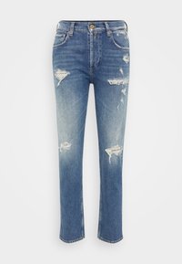 Jeans de mezclilla azul con corte recto, con desgastes y rotos, un diseño clásico de cinco bolsillos y un cierre de botón de latón en la cinturilla.