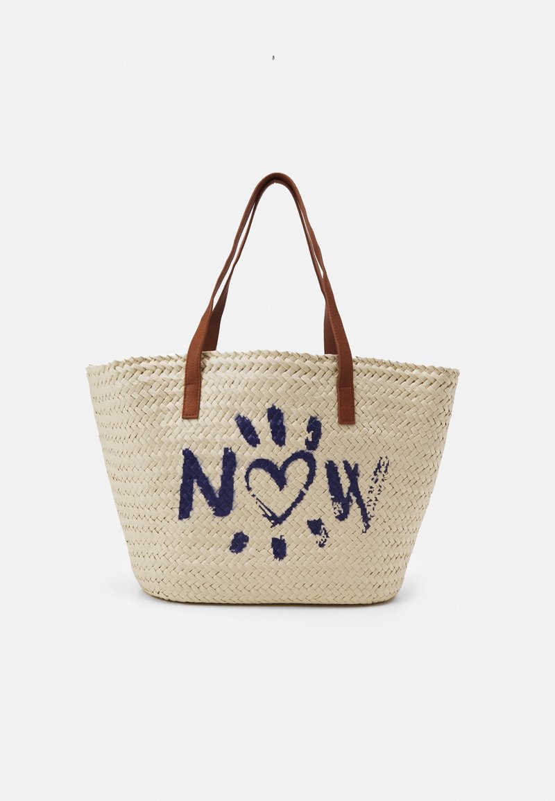 Pletená kabelka z slámy s hnědými rukojeťmi a modrým malovaným motivem s nápisem „NOW“, kde srdce nahrazuje písmeno „O“ na přední straně.