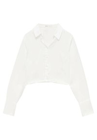 Chemise blanche raccourcie en tissu lisse et léger. Elle présente un col pointu et des manches longues avec poignets boutonnés.