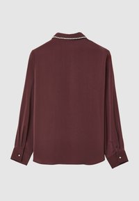 Blusa bordeaux a maniche lunghe con dettaglio a catena di perle sul colletto e bottoni di perla sui polsini, vista dal retro.
