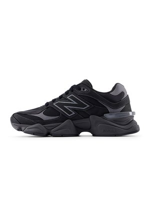 Black athletic sneakers with mesh and synthetic overlays, featuring a prominent gray logo, cushioned sole, and textured accents.
