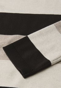 Sweter dzianinowy w beżowe, czarne i jasnobrązowe paski. Posiada prążkowane mankiety i miękką teksturę. Poziome paski o różnej szerokości.