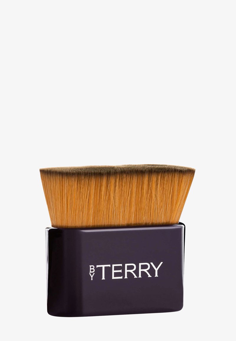 Make-up-Pinsel mit einem großen, flachen Kopf aus goldenen Borsten. Schwarzer rechteckiger Sockel mit silbernem Text "BY TERRY." Glatte Oberfläche mit glänzendem Finish.