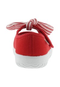 Scarpa bassa in tela rossa con suola in gomma bianca e fiocco in tessuto a righe rosse e bianche annodato sul retro.