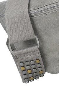 Borsa in tessuto grigia con superficie texturizzata, dotata di una cerniera argentata, manico grigio con borchie metalliche in accenti argentati e dorati.