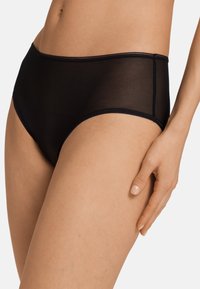 Zwarte high-waisted slips gemaakt van een transparante stof, met een gladde rand en minimale stiksels. Het ontwerp heeft een klassieke pasvorm.