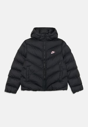 Chaqueta acolchada negra con capucha, que presenta un patrón de acolchado en zigzag y un cierre frontal con cremallera. Logotipo de Nike en rosa en el lado izquierdo del pecho.