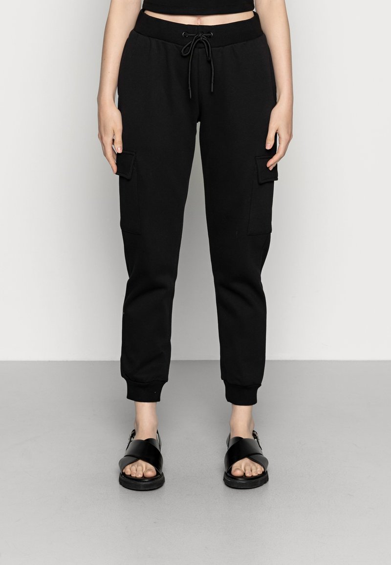 Pantalons cargo noirs avec des poignets élastiques et une taille à cordon de serrage, comportant deux poches latérales et une finition en tissu lisse et texturé.