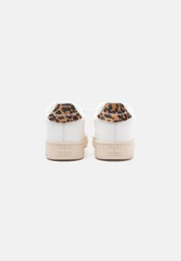 Λευκά sneakers με μπεζ σόλες και λεπτομέρειες με λεοπάρ σχέδιο στη φτέρνα. Διαθέτουν λείο δέρμα και ανάγλυφο λογότυπο στο πλάι.