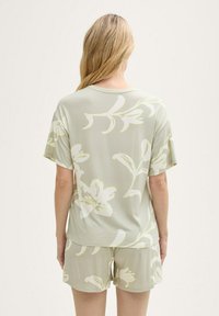 Conjunto de loungewear de estampado floral verde claro que incluye una camiseta de manga corta y pantalones cortos a juego, fabricado con una tela suave y transpirable.