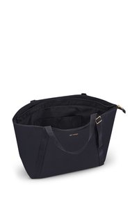 Zwarte canvas draagtas met een ruime binnenkant, voorzien van een logo in goudkleur en een ritsluiting. Inclusief twee stevige handvatten en binnenzakken.