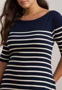 Navy and white striped dress with a scoop neckline and short sleeves, made from a soft, stretchy fabric. Notable horizontal stripes and pocket details.