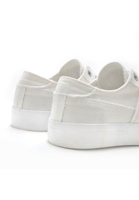 Weiße Segeltuch-Sneaker mit strukturierter Oberfläche, Gummisohlen und Metallösen. Das Design verfügt über eine low-cut Silhouette und kontrastierende Nähte.