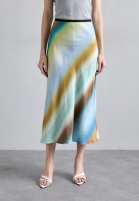 Jupe midi en soie à la conception fluide avec des rayures diagonales bleues, vertes et brunes. Fini avec une taille noire.