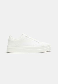 Sneakers bianchi con una superficie liscia, punta arrotondata, lacci davanti e una suola spessa e ammortizzata per il supporto.