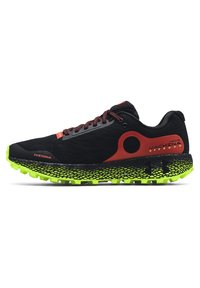 Scarpe sportive nere con accenti rossi e tomaia in rete. Presentano una suola verde testurizzata con lugs per la trazione e un cappuccio rinforzato.