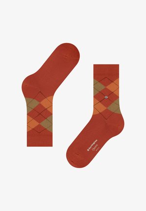 Rote Socken mit Argyle-Muster in Orange, Braun und Grün, mit glatter Textur und einem Logo auf der Unterseite einer Socke.