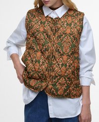 Gequilted vest in donkergroen met een oranje bloemenpatroon, voorzien van een hoge kraag, knopen aan de voorkant en twee zijzakken. Draagt over een witte shirt.