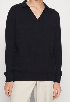 Pull noir en maille avec col en V, texture côtelée, manches longues et coupe décontractée. Adapté pour une tenue décontractée.