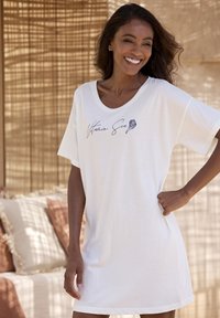 Abito in cotone bianco a t-shirt con scollatura rotonda, maniche corte e design con testo scritto a mano che presenta una grafica a forma di conchiglia. Texture morbida.