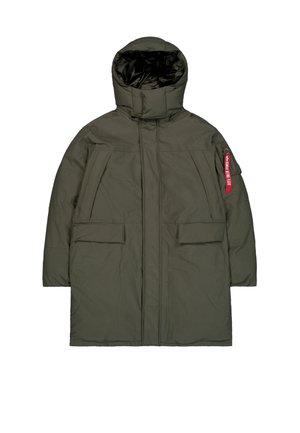 Parka de color verde oscuro, acolchada y con capucha de cuello alto, con cremallera frontal, bolsillos con solapa y una etiqueta roja "Remove Before Flight" en el bolsillo de la manga izquierda.