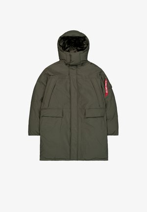 Dark green insulated parka coat with high collar hood, front zip, flap pockets, and a red "Remove Before Flight" tag on the left sleeve pocket.