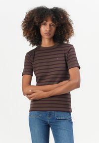 Gestreiftes T-Shirt in Dunkelbraun mit helleren Streifen, aus weichem Stoff gefertigt. Mit kurzen Ärmeln und Rundhalsausschnitt. Kleines Logo auf der Brust.