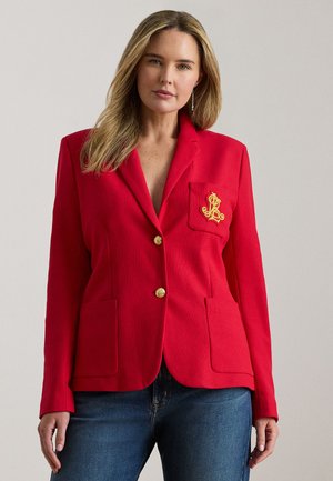 Sacou roșu cu nasturi aurii, buzunare frontale și un logo brodat pe buzunar. Confecționat dintr-un material texturat, cu o croială ajustată.