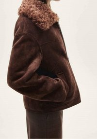 Brown suede jacket with a fluffy brown collar, zip closure, and side pockets; features a relaxed fit and smooth texture.