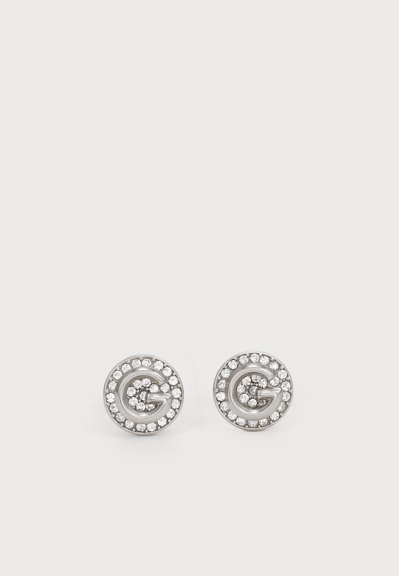 Silver stud earrings featuring a circular design with a prominent 'G' at the center, surrounded by small clear crystals.