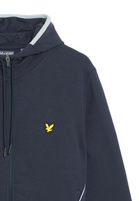 Navyblauwe hoodie van zachte stof, met een gele geborduurde adelaar op de borst en contrasterende grijze accenten op de capuchon.