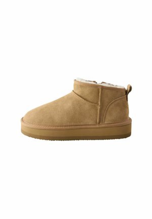 Braune Wildleder-Stiefeletten mit einem weichen Innenfutter, flacher Gummisohle und einer Rückziehschlaufe, die durch minimalistisches Design und klare Linien besticht.