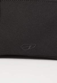 Black fabric bag featuring a textured surface and a subtle, embossed logo design. The color is uniform with no visible patterns or accents.